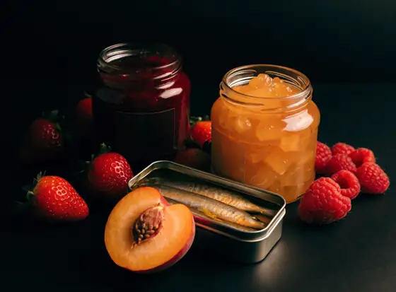 Jam jars and a tin of sardines with fruit